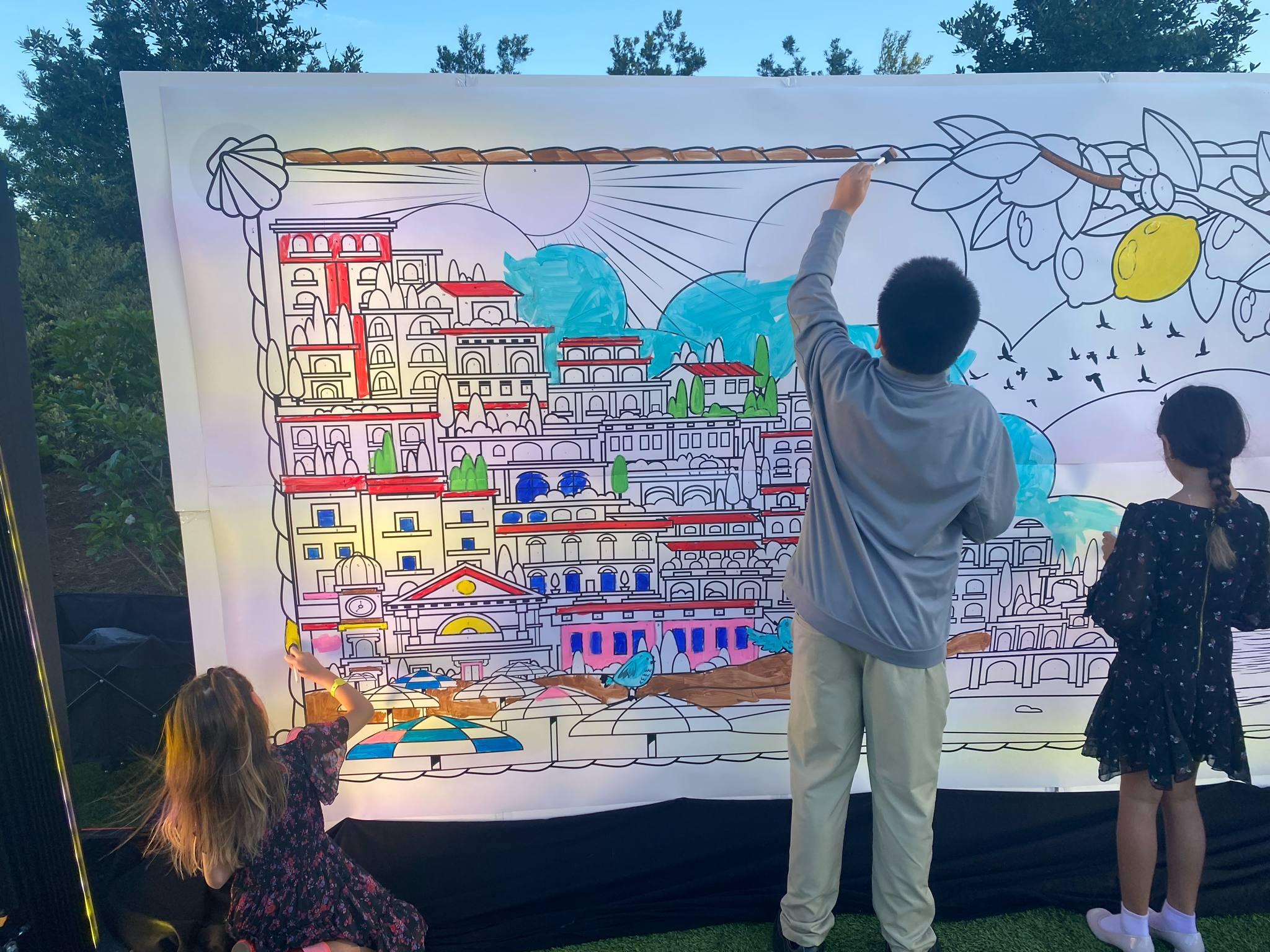 Kids color in a large color by number mural